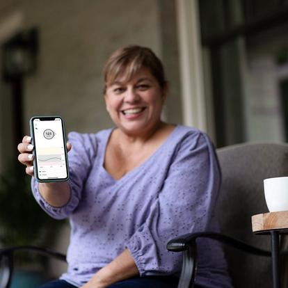 Woman holding out smartphone showing glucose levels