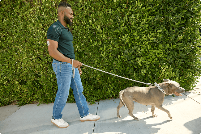 Man walking his dog outside while wearing Stelo sensor