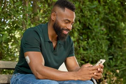 man checking phone on a bench