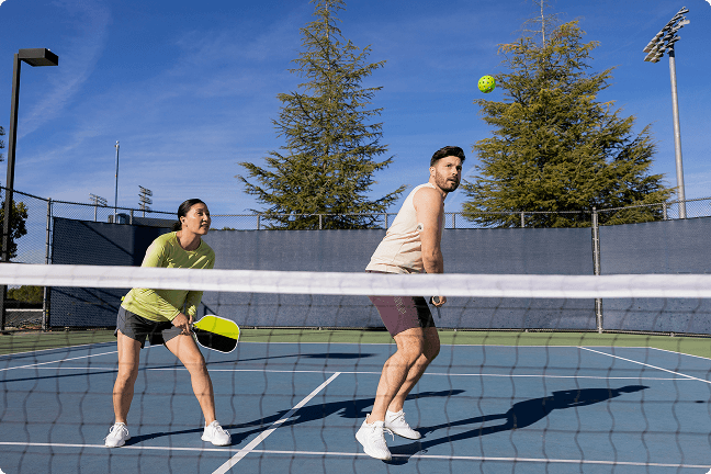 A younger couple playing pickleball