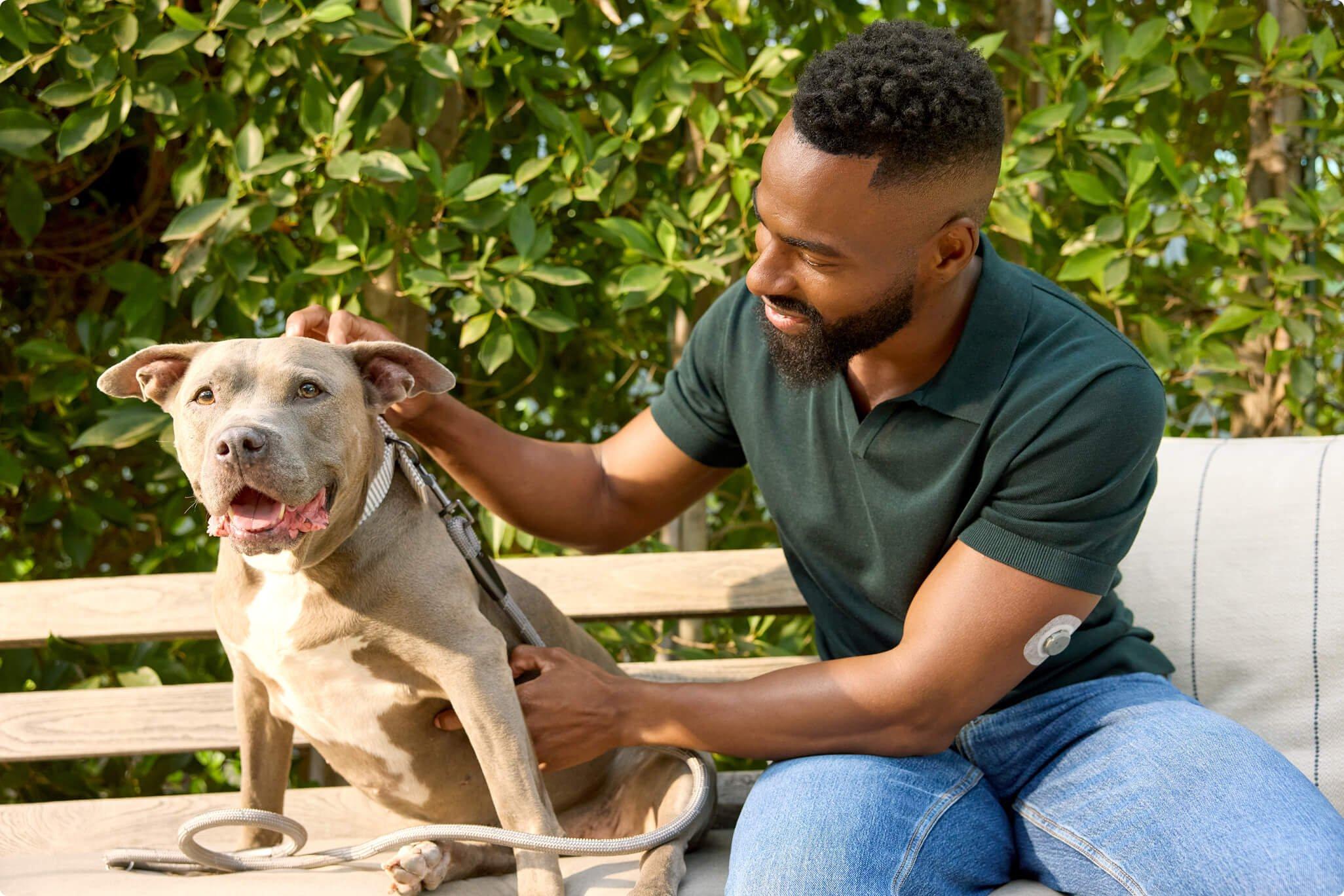 Man wearing Stelo sensor petting his dog