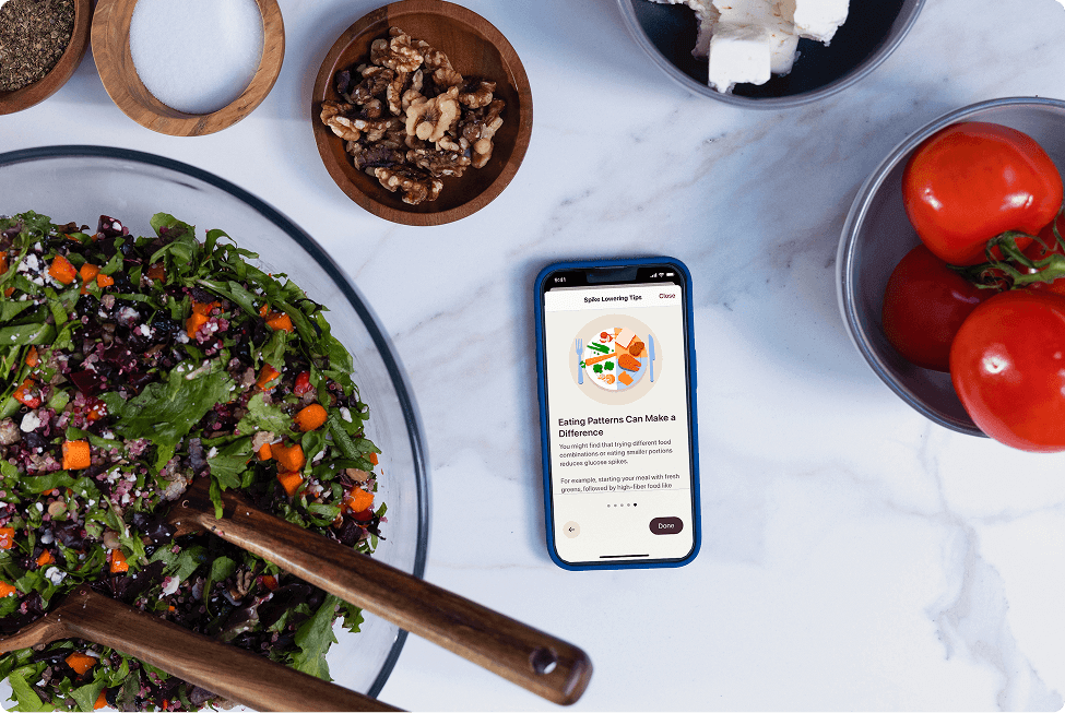 Phone on a table next to a salad bowl