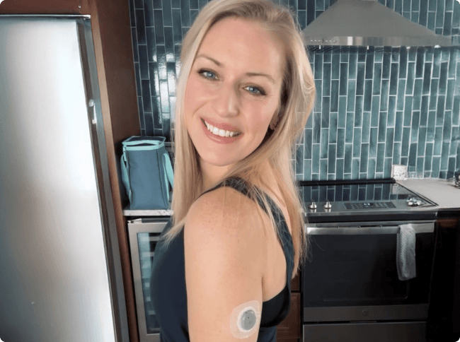 Woman smiling at the camera while wearing her Stelo sensor