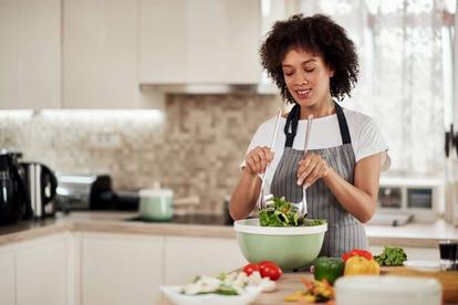 Woman mixing a salad in her kitchen