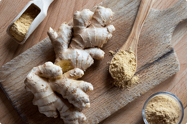 Ginger root and ground ginger sitting on a cutting board