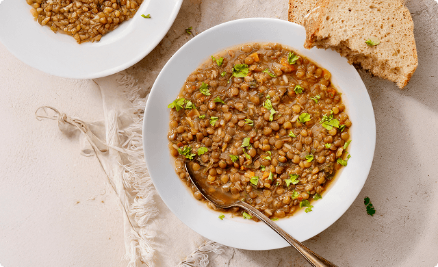 Bowl of lentil stew garnished with herbs
