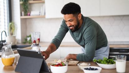 Man in the kitchen preparing to blend a smoothie
