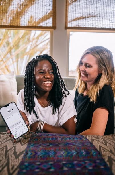 Keary and Zola smiling showing glucose readings on smart device using Dexcom G7 CGM app