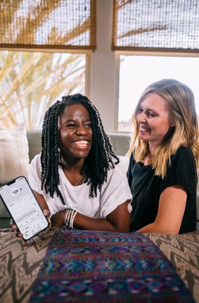 Keary and Zola smiling showing glucose readings on smart device using Dexcom G7 CGM app