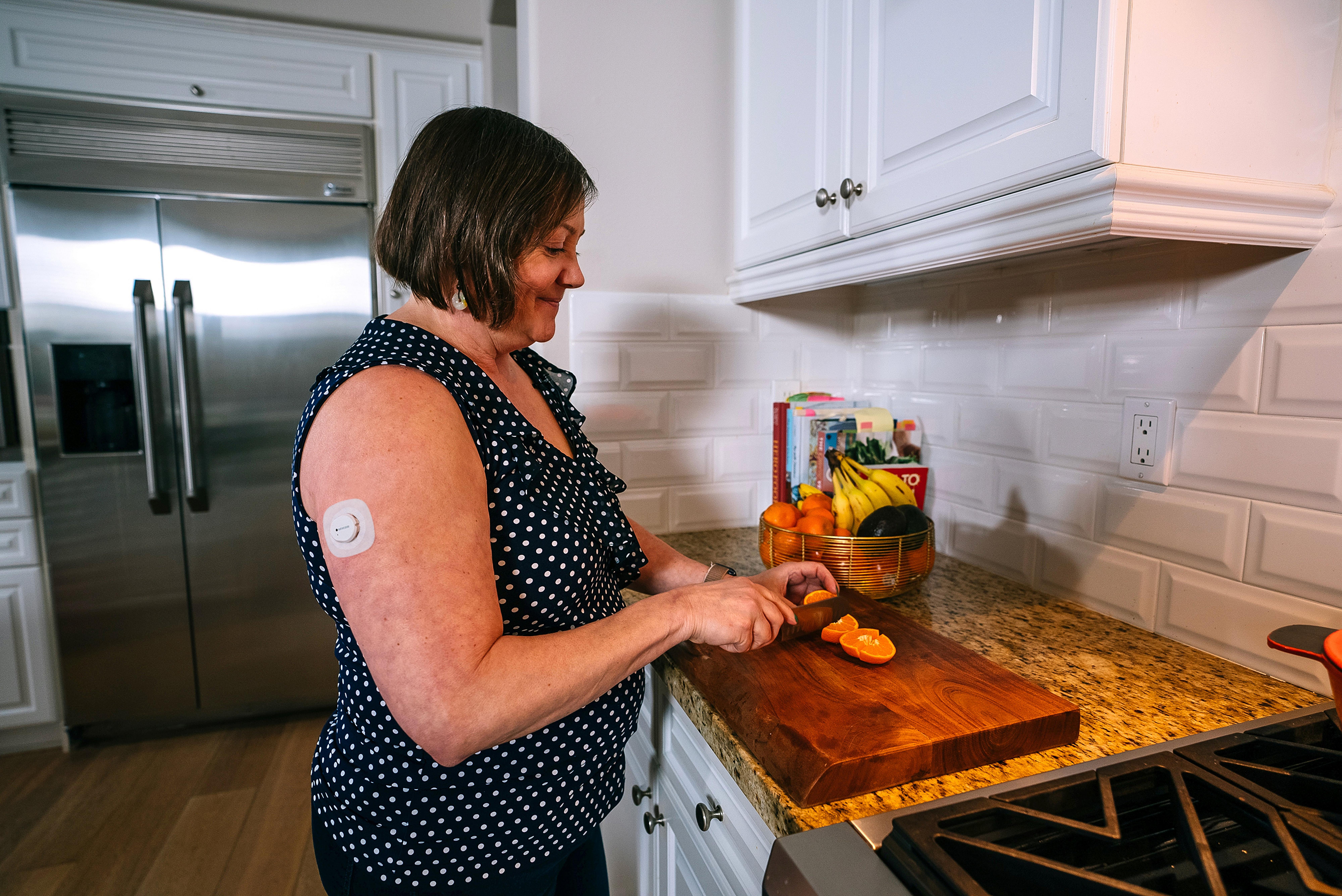 Biz V cutting some fruit wearing Dexcom CGM Overpatch - Use Overpatch as instructed