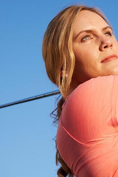 Ženska, ki igra golf s senzorjem Dexcom G7 na zgornjem delu roke