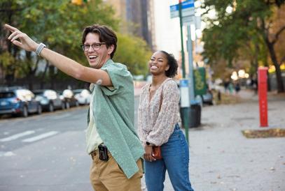 Giovane uomo in una strada di città che alza il braccio con un sensore Dexcom G7 sul braccio superiore
