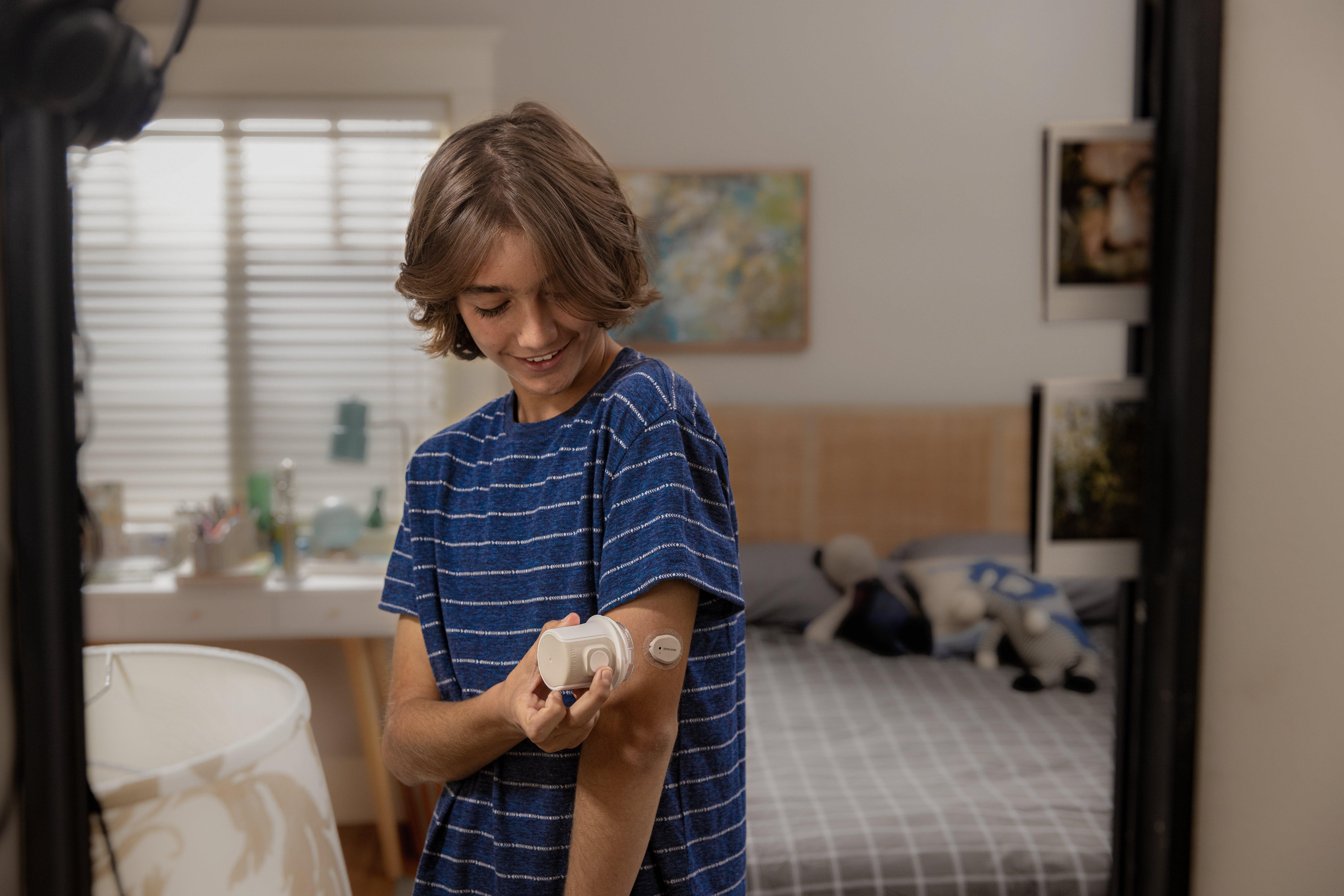 Teenager beim Anbringen des Dexcom G7-Sensors mit dem Applikator