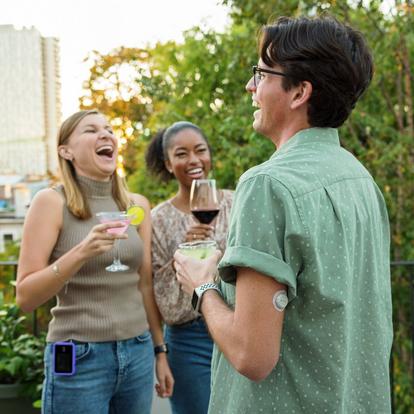 Freunde lachen bei einem Drink, während sie das Dexcom G7 CGM tragen