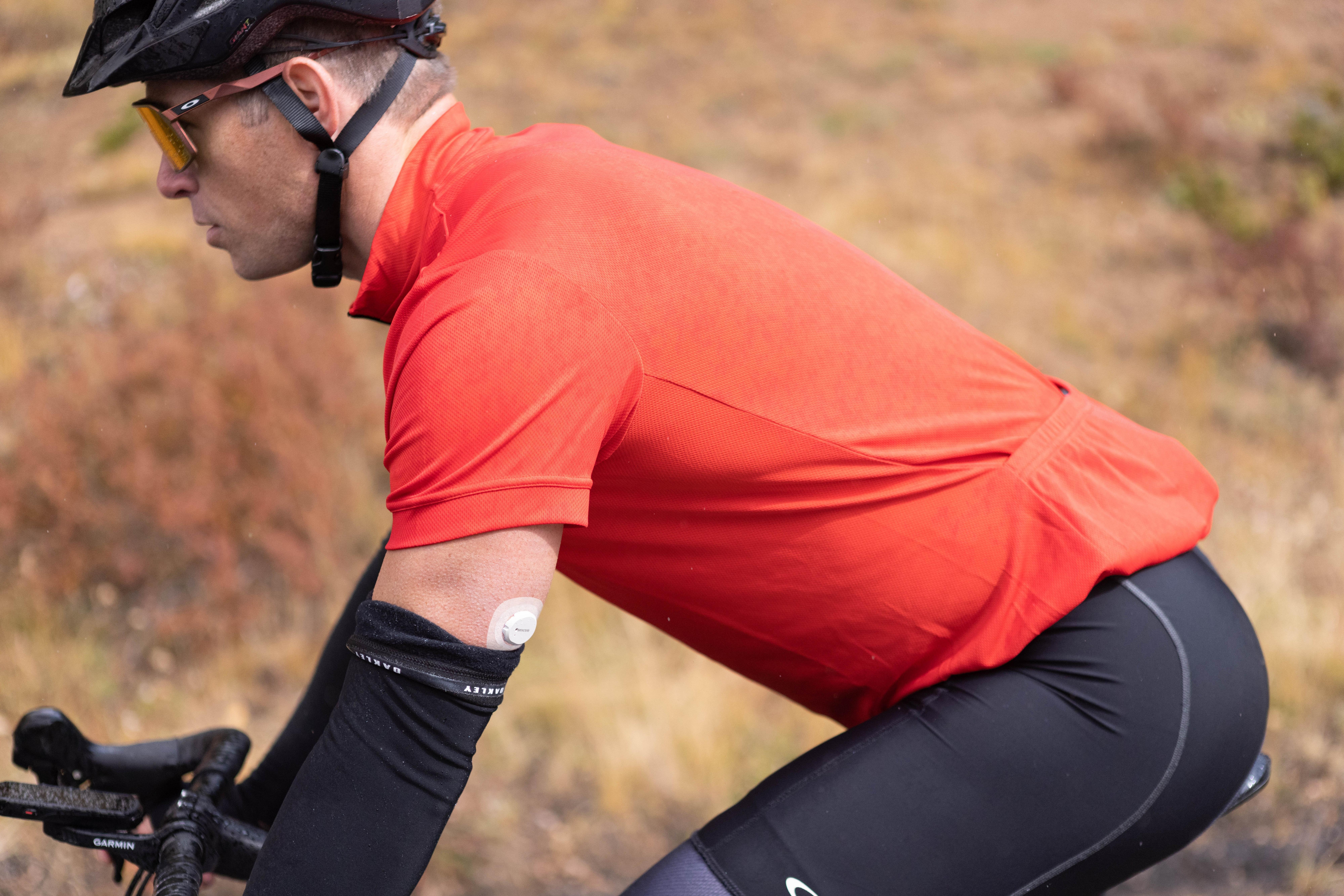 man riding bike with dexcom sensor on arm