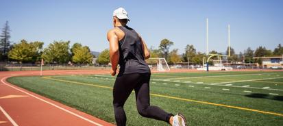Man running on a race track while wearing the Dexcom sensor