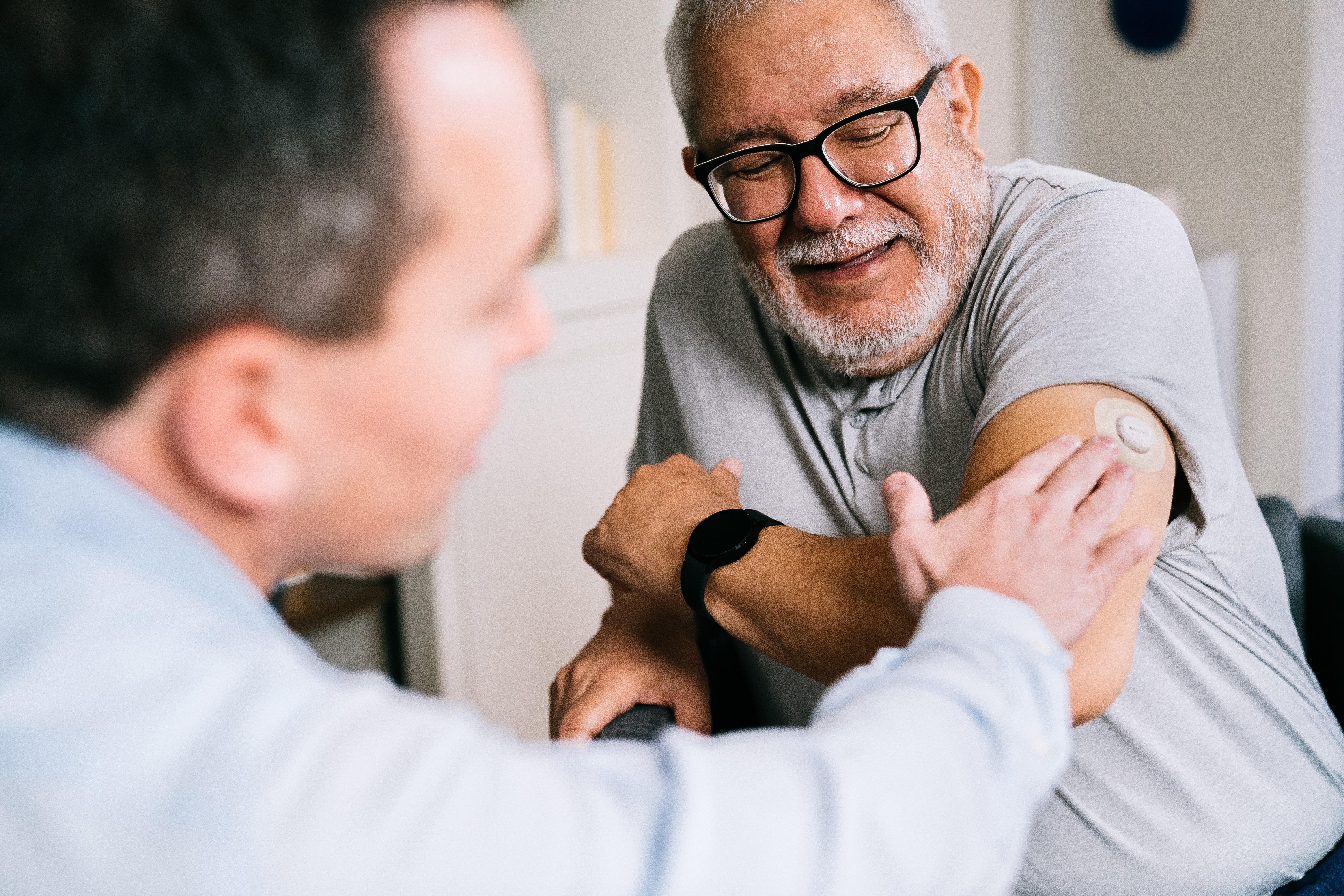 man applying Dexcom CGM device on the back of his arm