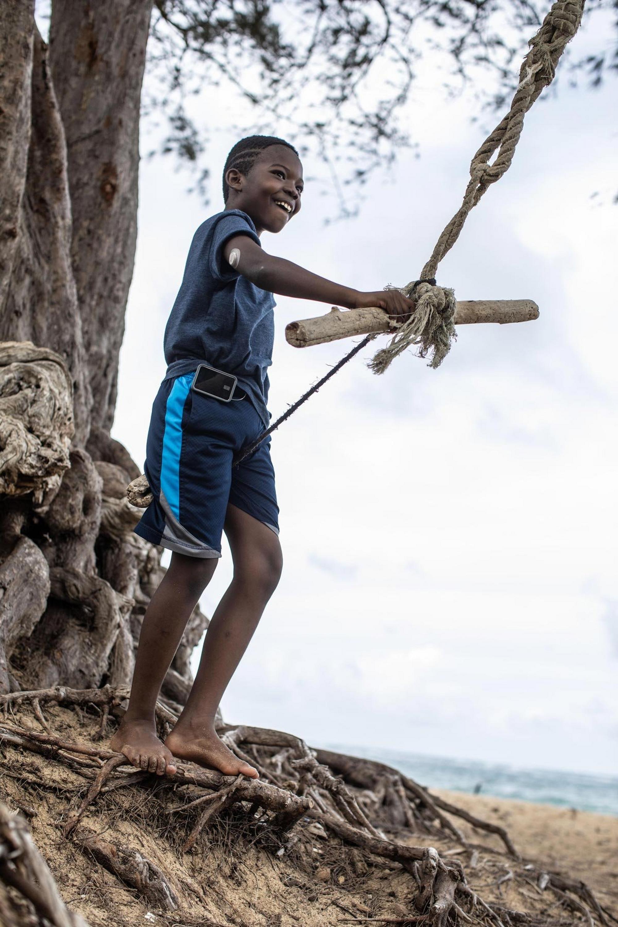 Child swinging on a rope into water