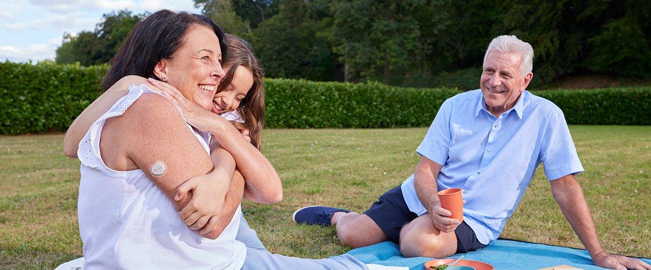 woman wearing the Dexcom ONE+ sensor having a picnic