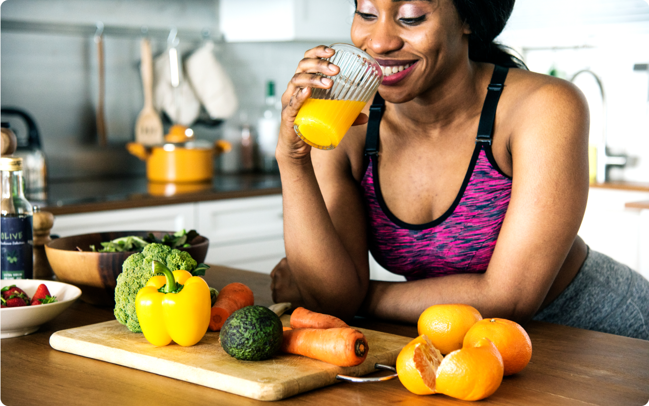 Woman Making fresh cup of Orange Juice in Kitchen