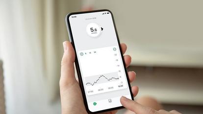 Pametni telefon prikazuje aplikaciju Dexcom ONE s očitavanjem vrijednosti glukoze