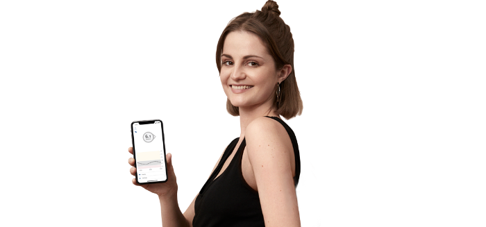 A woman holding her smart device displaying real-time glucose readings