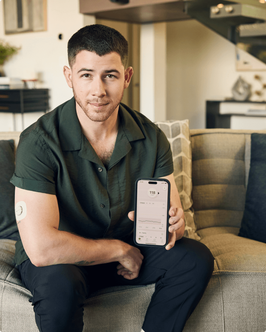 Nick Jonas wearing the dexcom sensor and showing reading on his smartphone