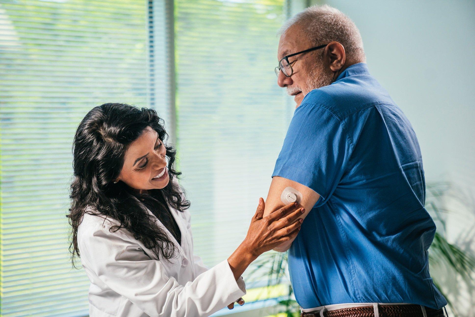 Doctor applying dexcom sensor to patient 