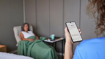 Nurse in hospital reading glucose values on Dexcom app on phone