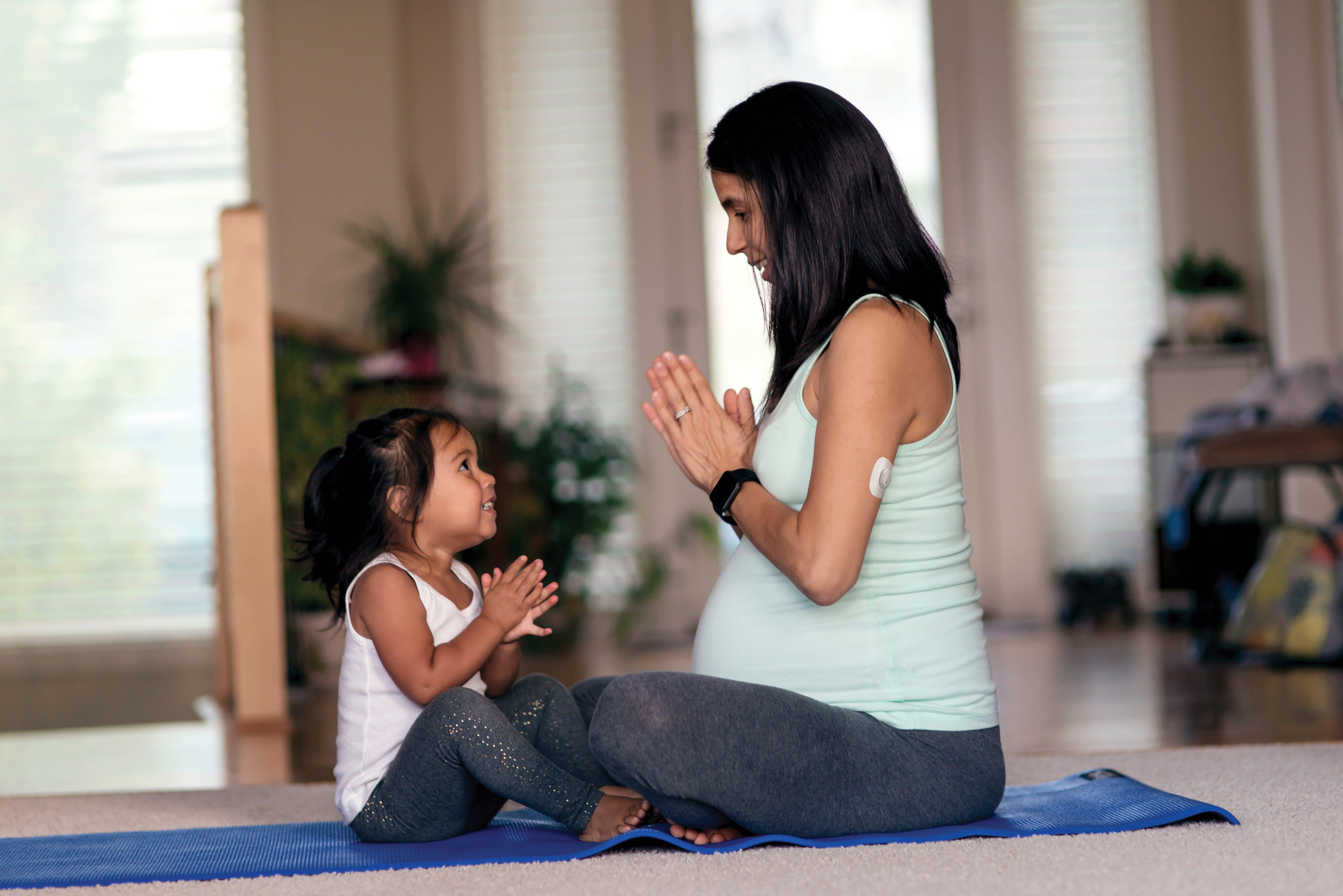 pregnant woman and daughter doing yoga together