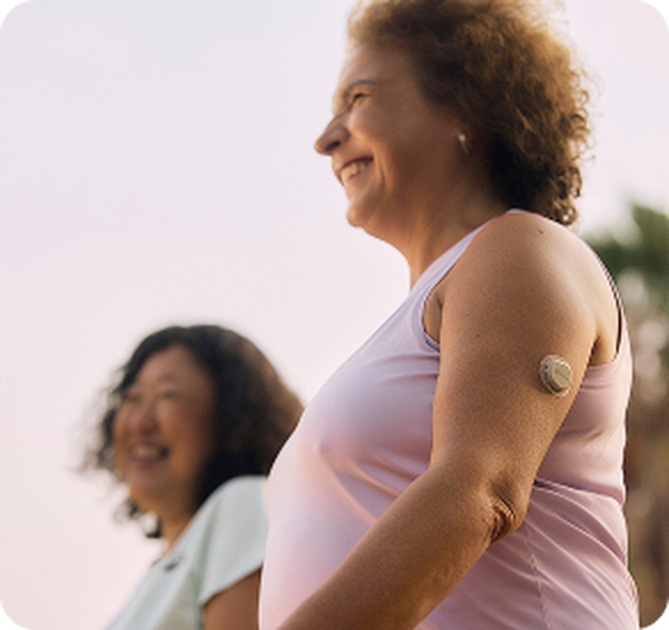 woman smiling with her friend while wearing the Dexcom CGM