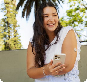 Woman smiling, wearing the Dexcom CGM on her arm