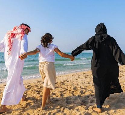 3 persons walking in the beach while holding hands