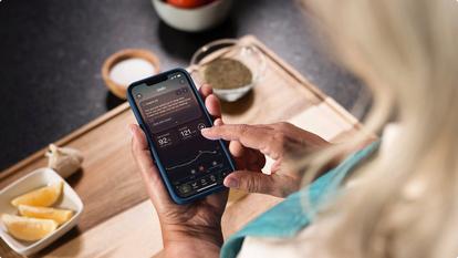 Woman checking Stelo app in kitchen