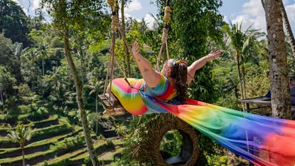 Stelo Ambassador Alysse wearing rainbow dress on swing