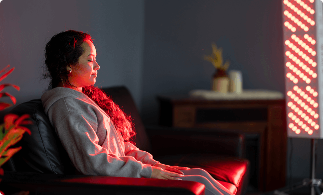 Woman sitting on couch with red light shining on her