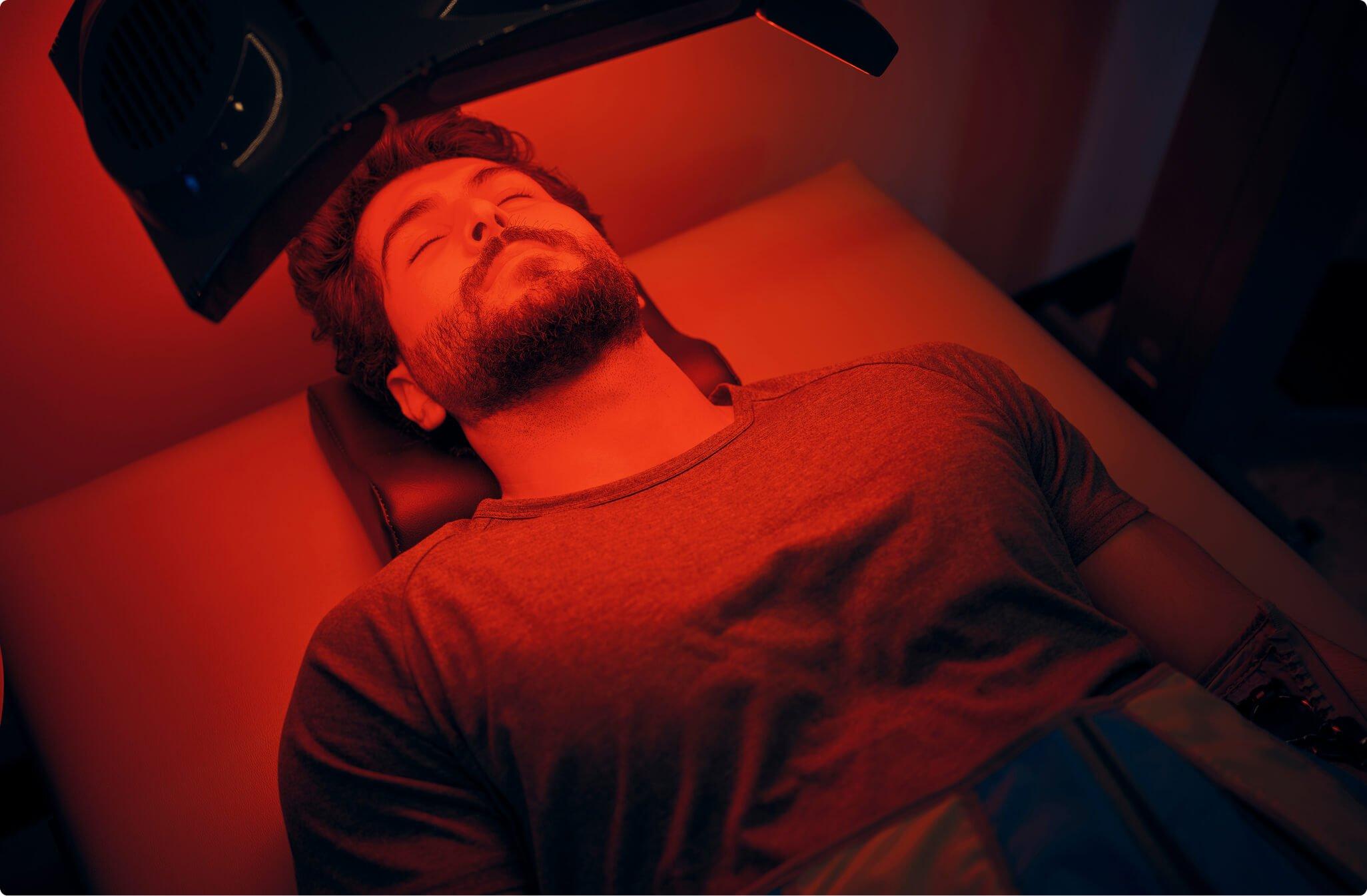 Man laying down with red light shining on him