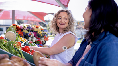 Women at the farmers market wearing the Dexcom sensor and talking