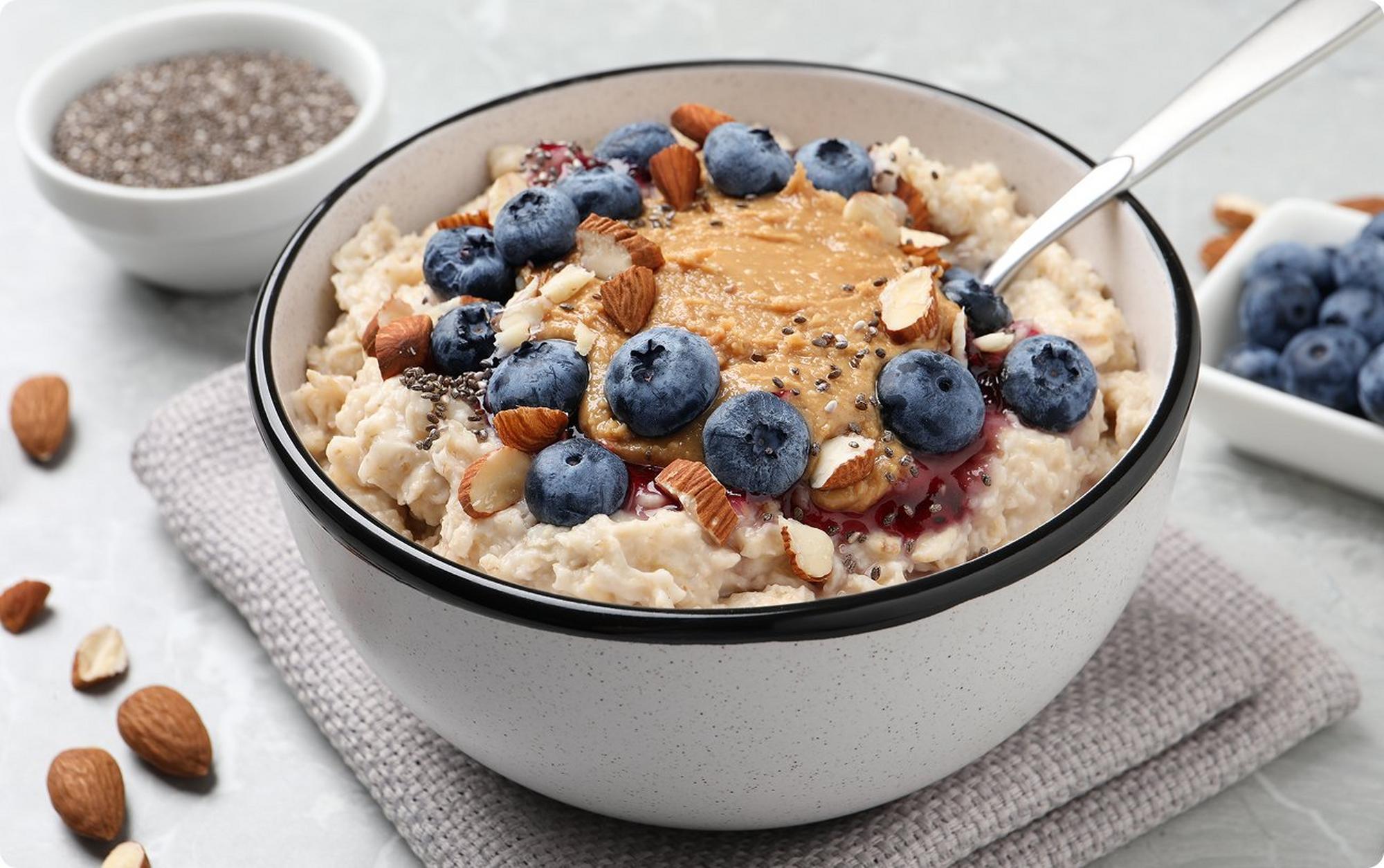bowl of oatmeal with chia seeds, peanut butter, nuts, and blueberries