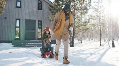 Dad pulling kids on snow sled