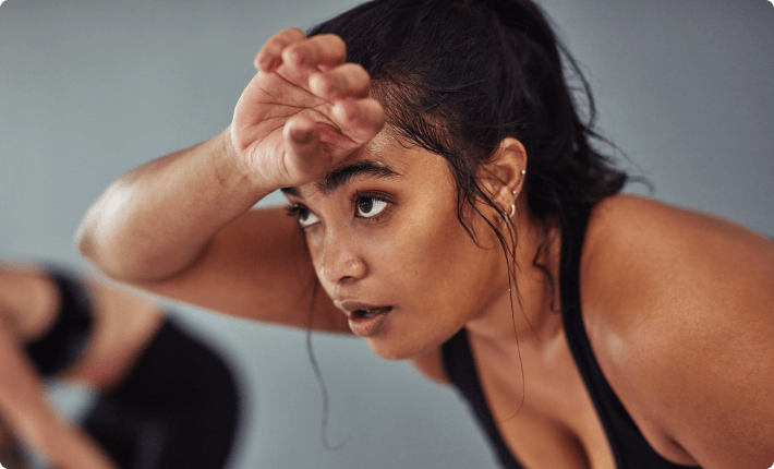 Woman wiping sweat of her forehead