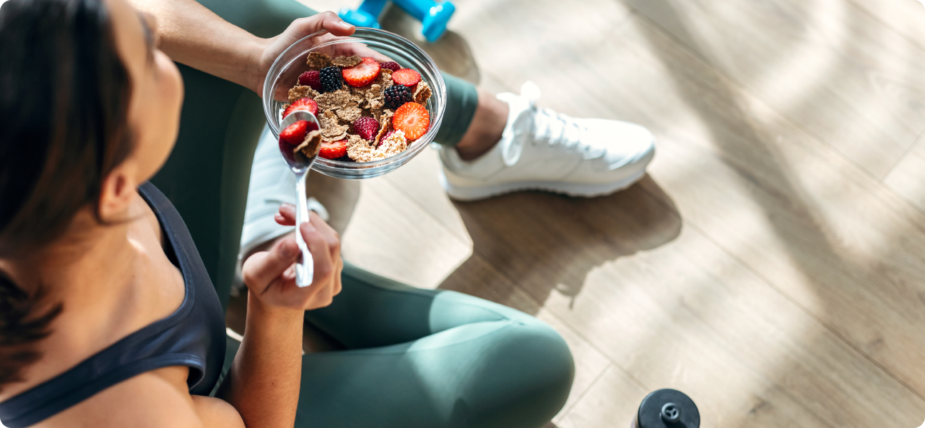Woman eating bowl of mixed fruit and cereal