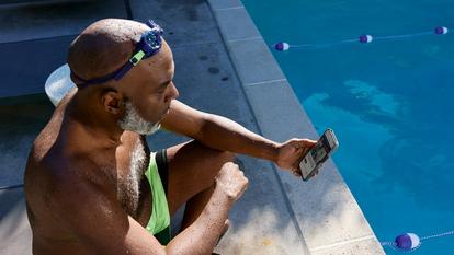 Man sitting by pool looking at Stelo app