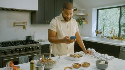 Man in kitchen looking at phone