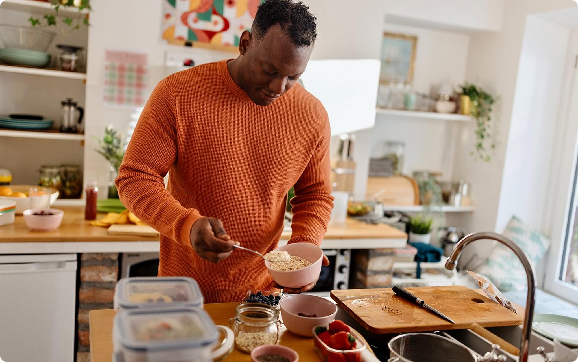 Man making a bowl of oatmeal with toppings