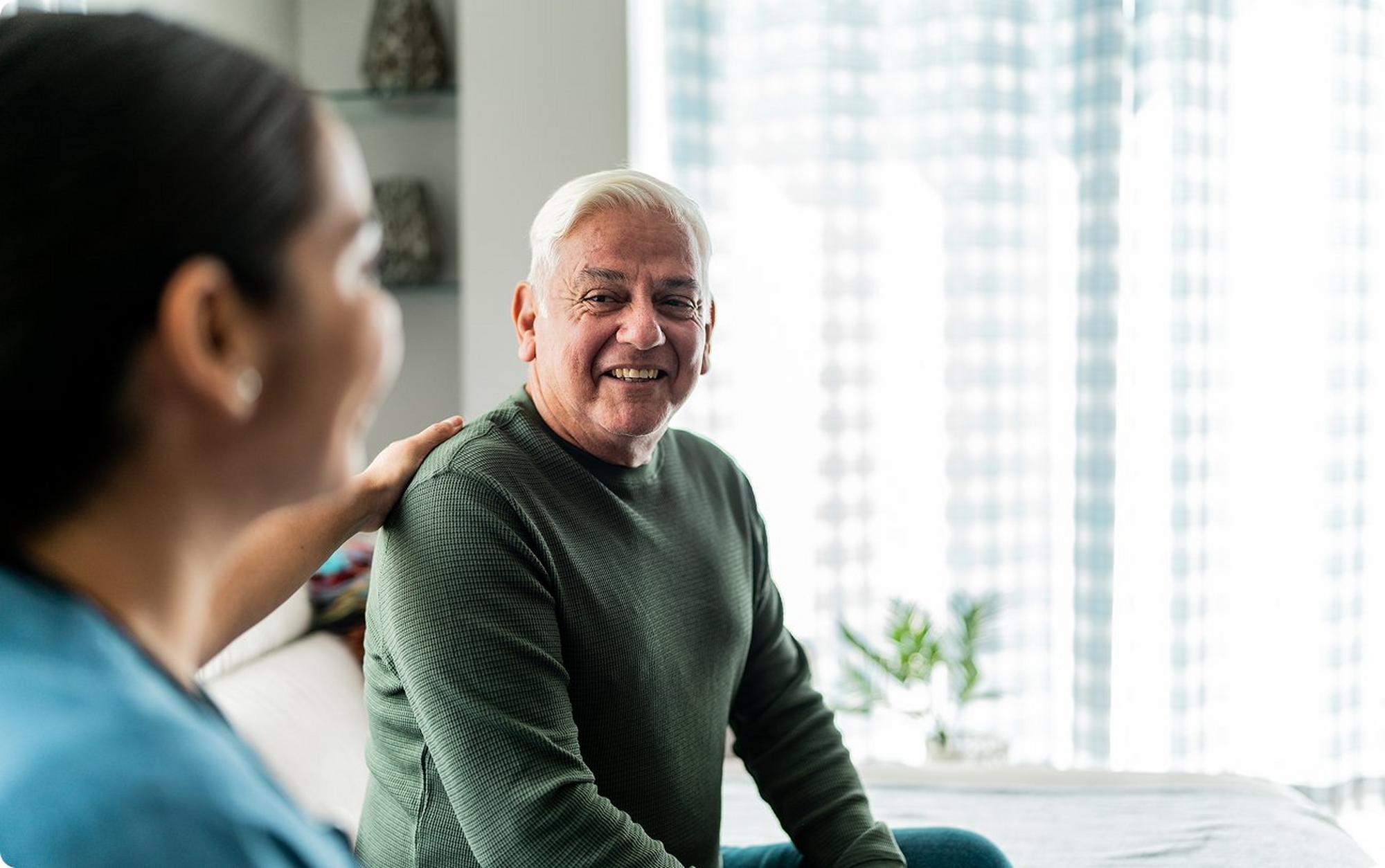 Senior man speaking with nurse at appointment