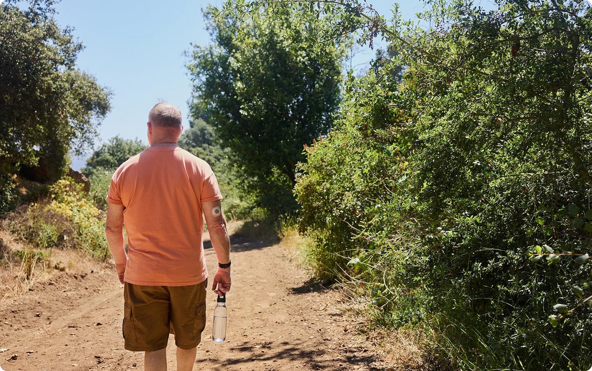 man hiking outdoors holding a water bottle
