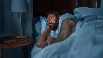 man sleeping in bed wearing stelo glucose biosensor