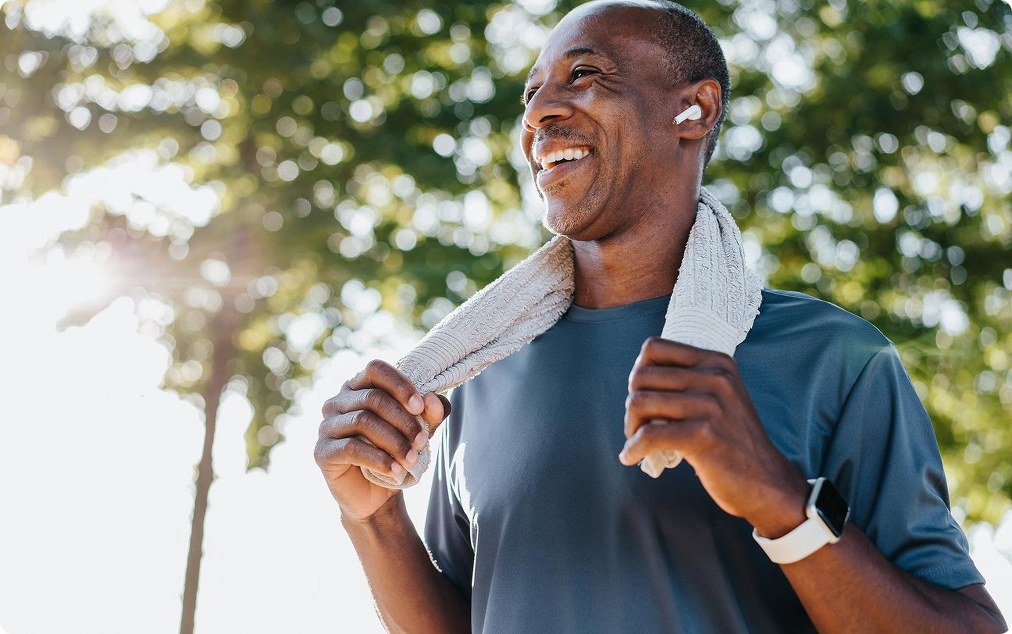 man with towel around neck wearing ear buds