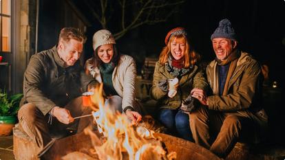 People sitting outside by firepit